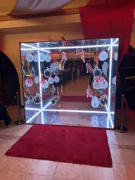 Cabina personalizada con elementos rosas sobre paredes espejadas