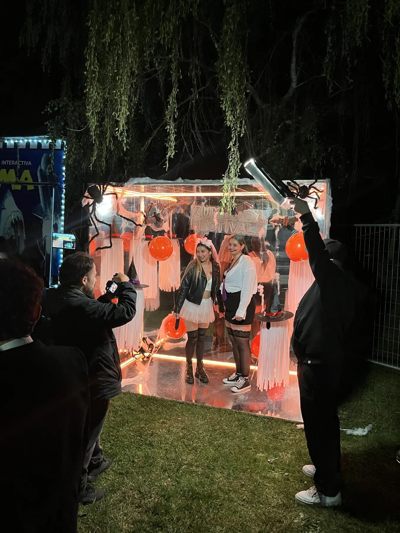 Cabina personalizada con globos naranjas y blancos en un jardín