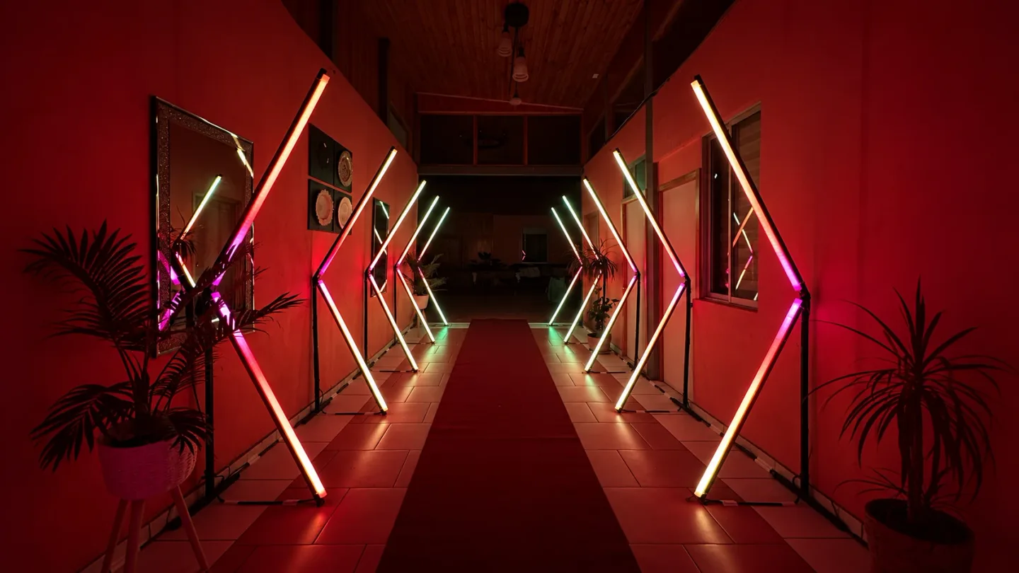 Túnel LED Pixel con luces cálidas y magenta, visto de frente sobre la alfombra roja